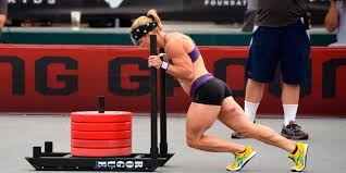 no hay peros para hacer ejercicio. Hermosa mujer joven con ropa deportiva  agachada usando una banda de resistencia mientras está de pie en la pista  de atletismo al aire libre 13450340 Foto